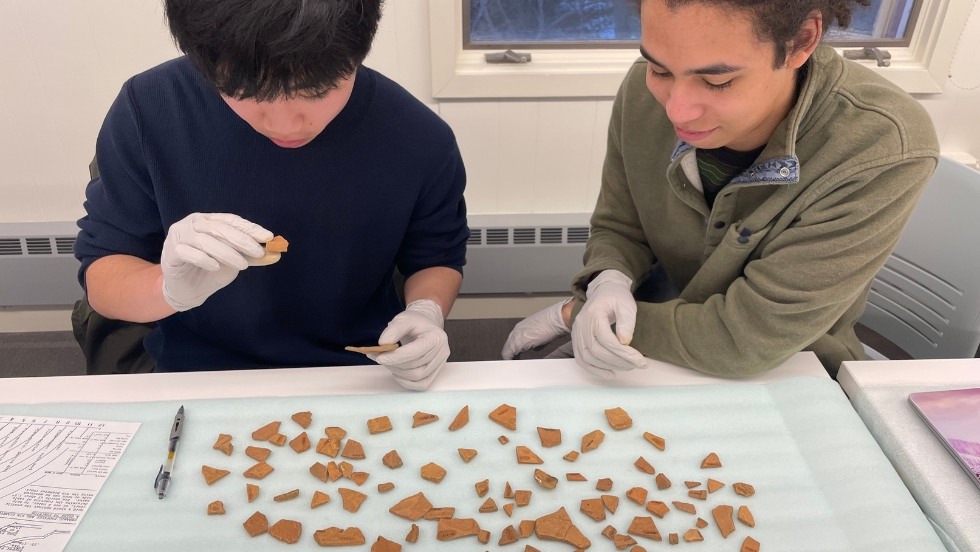 Students in the Historical Archaeology Lab (HA Lab) examine redware shards from the Cocumscussoc Collection