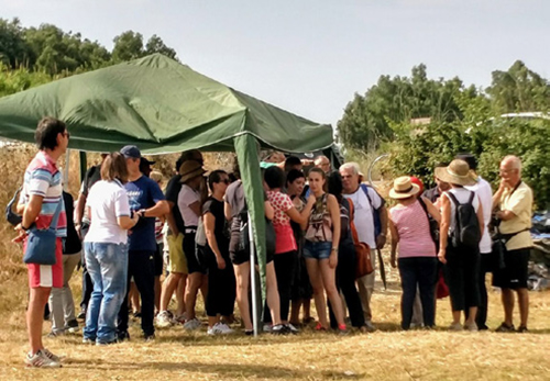 People standing under green tent