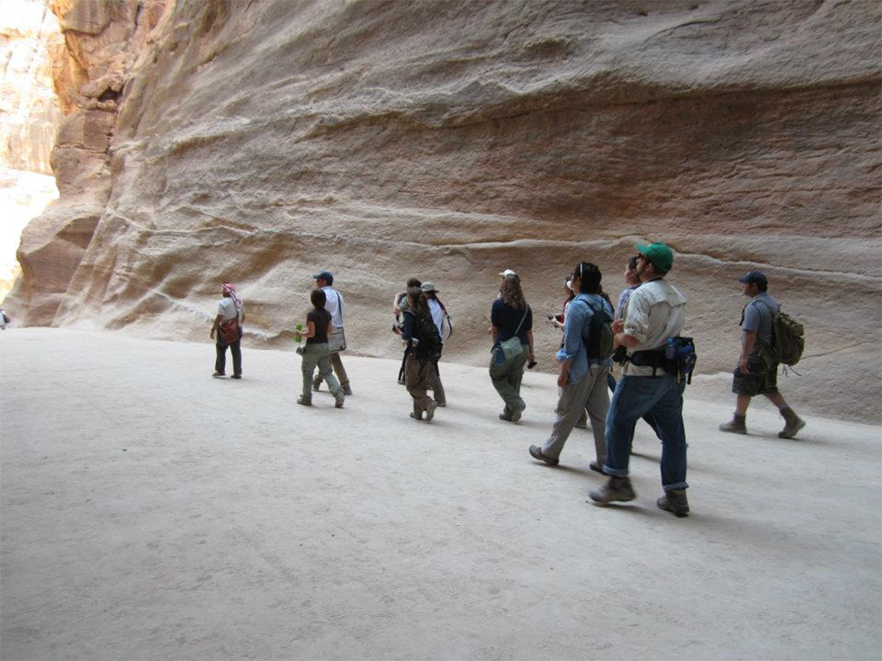 A team walks through a canyon in Petra, Jordan